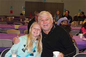 female student with blonde hair sitting with father 